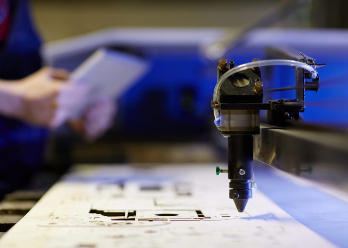 Laser cutting beam over plywood sheet